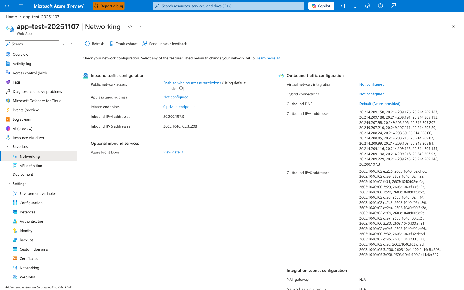 Networking blade for the Web App with a minimal command bar offering Refresh, Troubleshoot, and Send us your feedback. An info banner reads "Check your network configuration. Select any of the features listed below to change your network setup. Learn more". The blade is split into Inbound traffic configuration and Outbound traffic configuration columns. Inbound shows Public network access "Enabled with no access restrictions (Using default behavior)" as a link, App assigned address "Not configured", Private endpoints "0 private endpoints", Inbound IPv4 addresses "20.200.197.3", and Inbound IPv6 addresses "2603:1040:f05:3::208". An Optional inbound services subsection lists Azure Front Door with a "View details" link. Outbound shows Virtual network integration "Not configured", Hybrid connections "Not configured", Outbound DNS "Default (Azure-provided)", Outbound IPv4 addresses (a long comma-separated list of roughly 30 addresses across the 20.214.x.x and 20.249.x.x ranges), and Outbound IPv6 addresses (a similarly long comma-separated list of IPv6 prefixes). An Integration subnet configuration section at the bottom shows NAT gateway "N/A". The left navigation has Networking highlighted under the Favorites group, with the Settings group expanded below it.