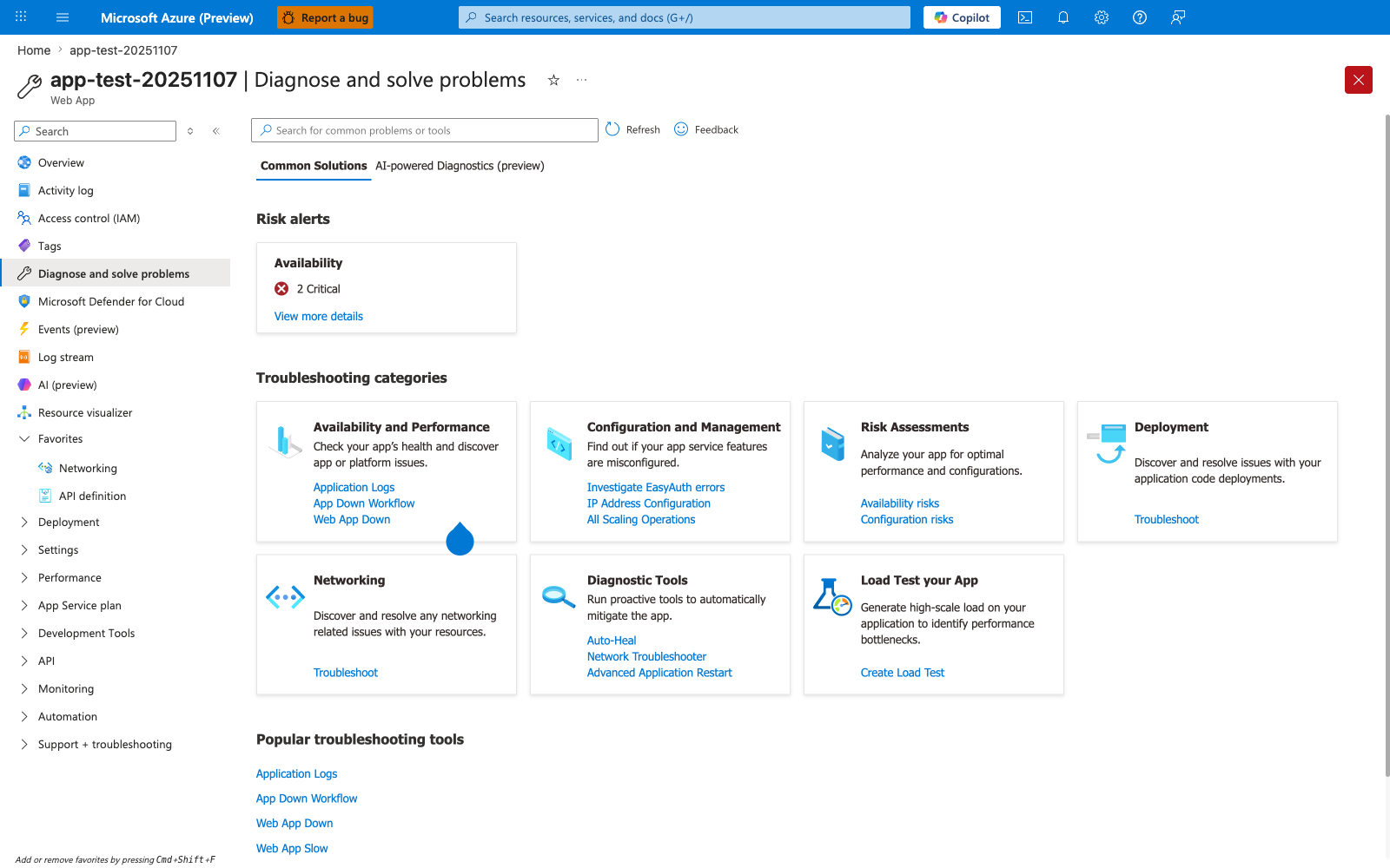 Azure portal Diagnose and solve problems blade for app-test-20251107 (Web App). The blade header shows the resource title with Favorite (star) and More content actions (...) buttons on the left, and a prominent red Close (X) button at the far right. Below the header, the toolbar shows a Search for common problems or tools box, a Refresh button, and a Feedback button. Two tabs are visible: Common Solutions (selected and underlined) and AI-powered Diagnostics (preview). The Risk alerts section at the top displays a single card titled Availability with a red X icon, the count 2 Critical, and a View more details link. Below that, the Troubleshooting categories section shows seven tiles arranged in two rows: Availability and Performance with sub-links Application Logs, App Down Workflow, Web App Down; Configuration and Management with sub-links Investigate EasyAuth errors, IP Address Configuration, All Scaling Operations; Risk Assessments with sub-links Availability risks, Configuration risks; Deployment with sub-link Troubleshoot; Networking with sub-link Troubleshoot; Diagnostic Tools with sub-links Auto-Heal, Network Troubleshooter, Advanced Application Restart; and Load Test your App with sub-link Create Load Test. The Popular troubleshooting tools section at the bottom lists Application Logs, App Down Workflow, Web App Down, and Web App Slow as quick-access links. The left navigation panel highlights Diagnose and solve problems as the active blade, with Overview, Activity log, Access control (IAM), Tags, Microsoft Defender for Cloud, Events (preview), Log stream, AI (preview), Resource visualizer, Favorites (expanded with Networking and API definition), Deployment, Settings, Performance, App Service plan, Development Tools, API, Monitoring, Automation, and Support + troubleshooting also visible.